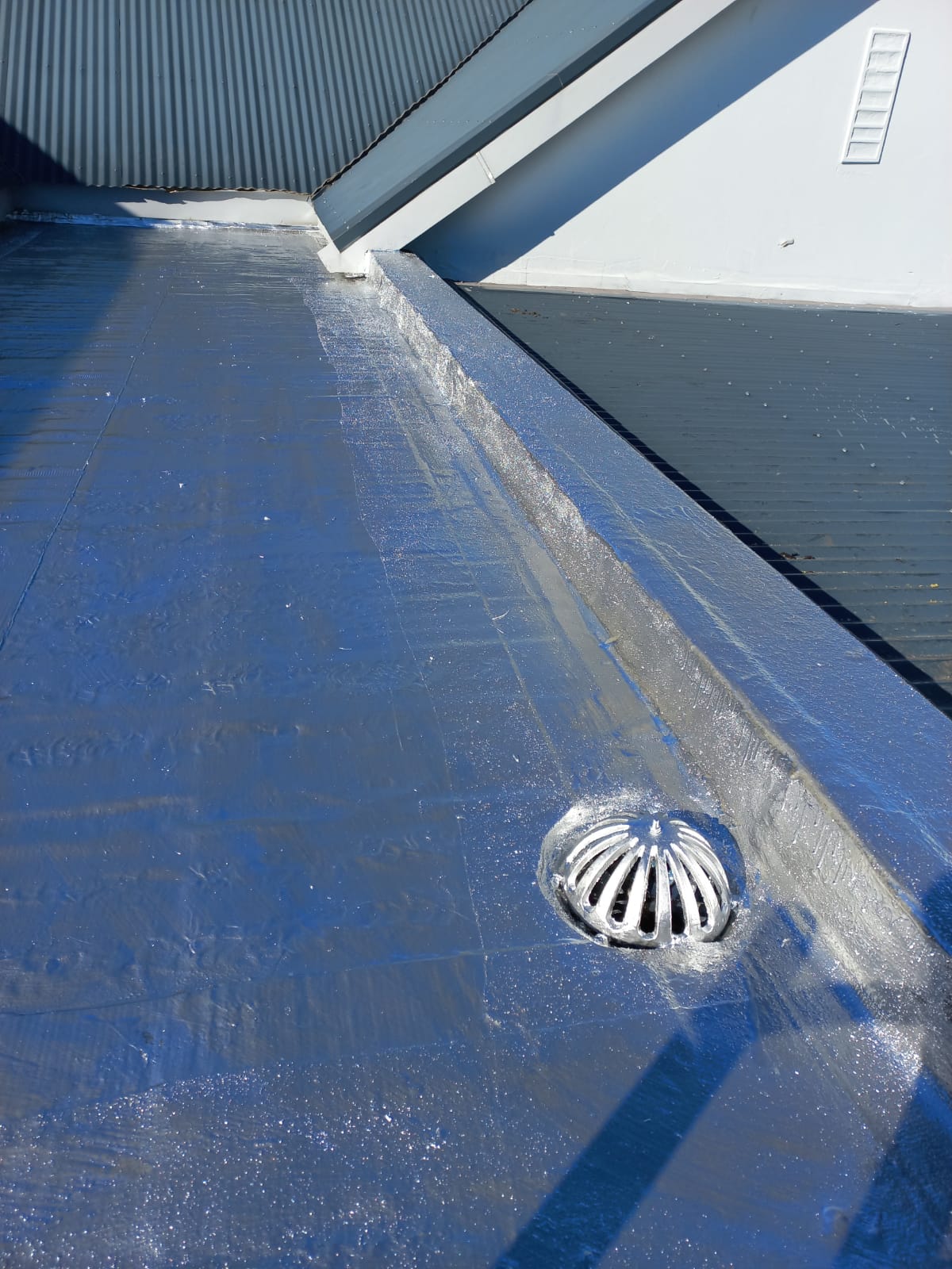 Rainwater outlet dressed into a reflective flat roof membrane