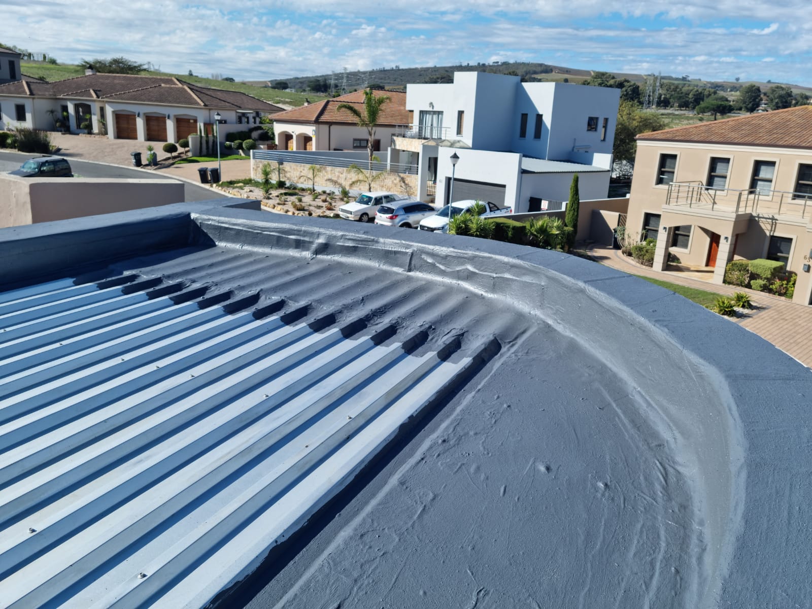 Flat roof and curved parapet finished above a winelands estate