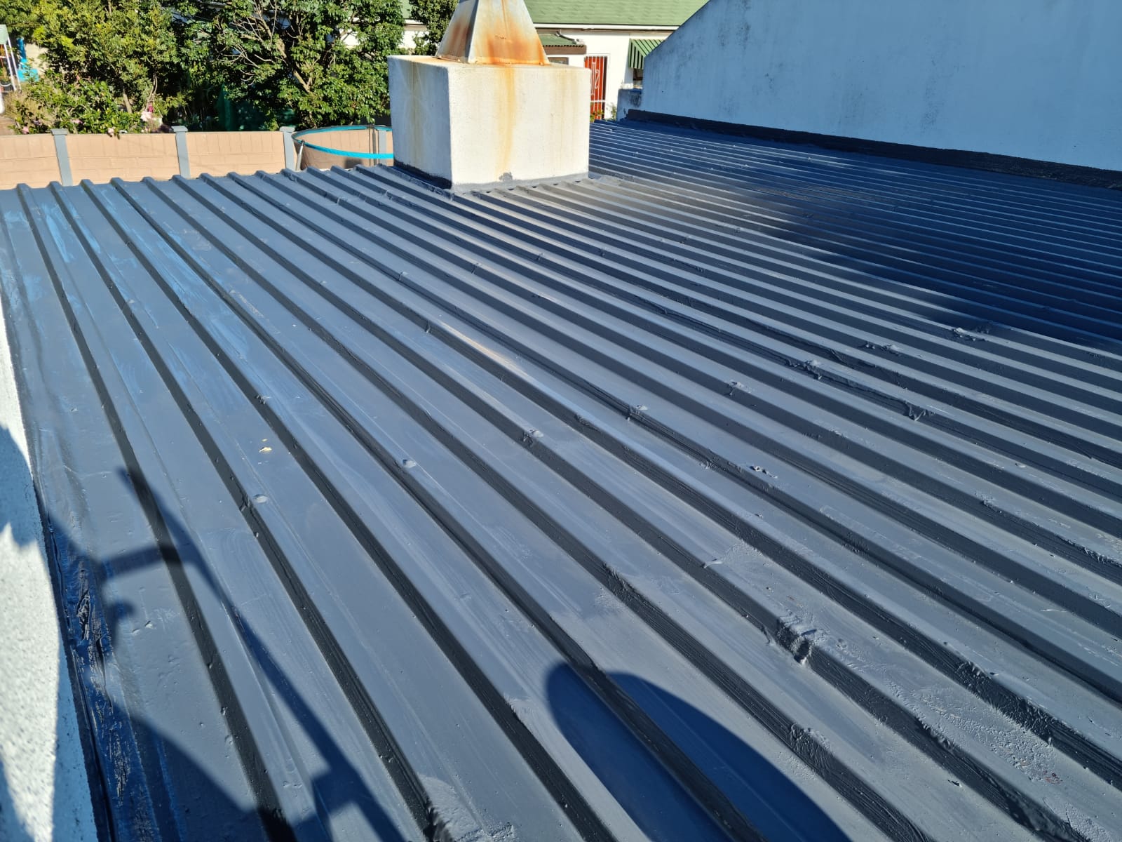 Sheet roof coated in charcoal, with every seam and fixing sealed