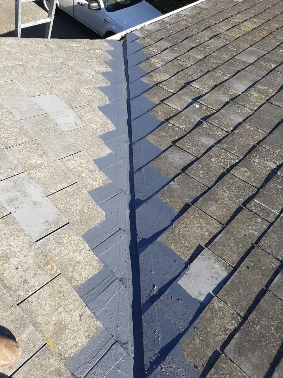 Valley of a tiled roof stripped, sealed and coated between the tile courses